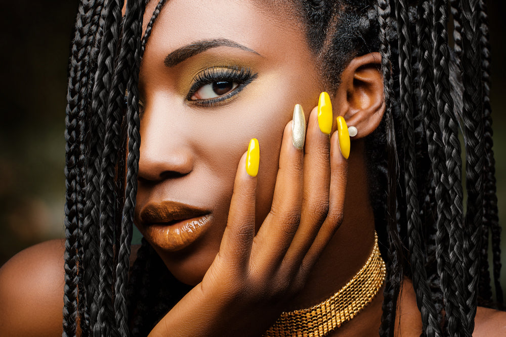 Girl with braided hairstyle and sensual look against dark background