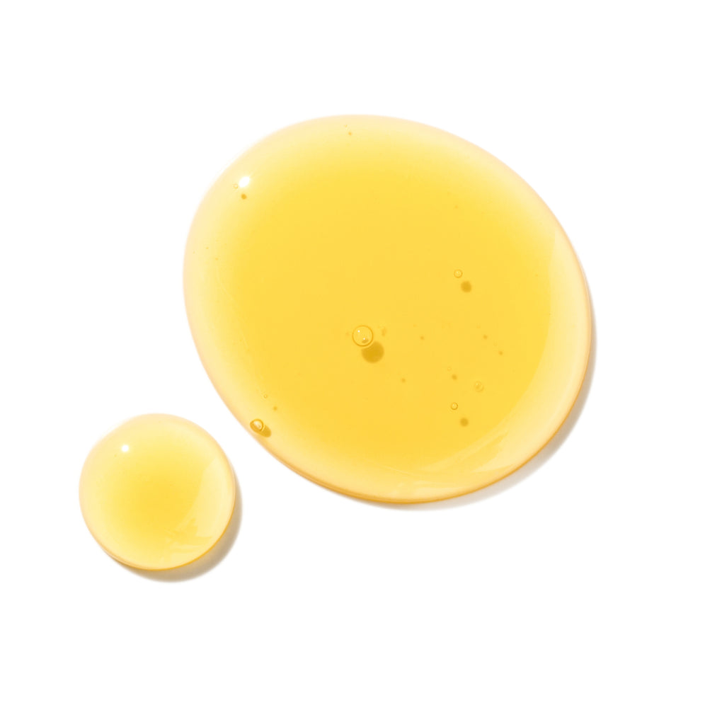Yellow liquid drops, showcasing Mielle Organics hair care product texture.