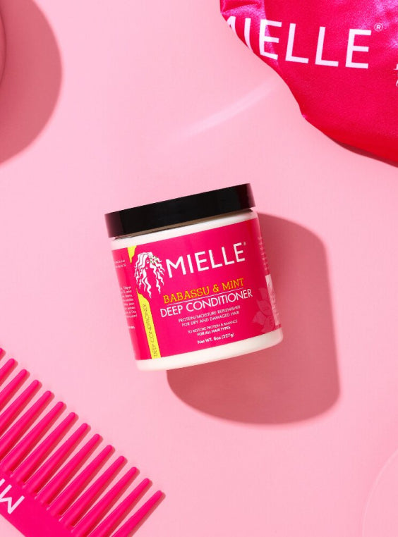 Mielle Organics Babassu & Mint Deep Conditioner on pink background.