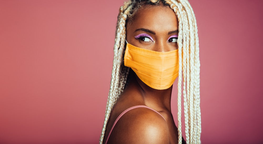 Young african woman with blonde box braids wearing protective face mask