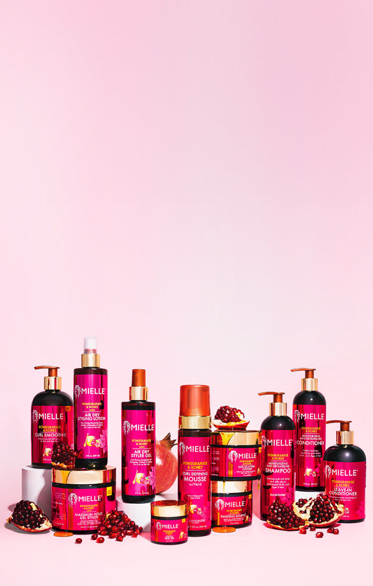 Collection of pink skincare and hair care products on a pink background