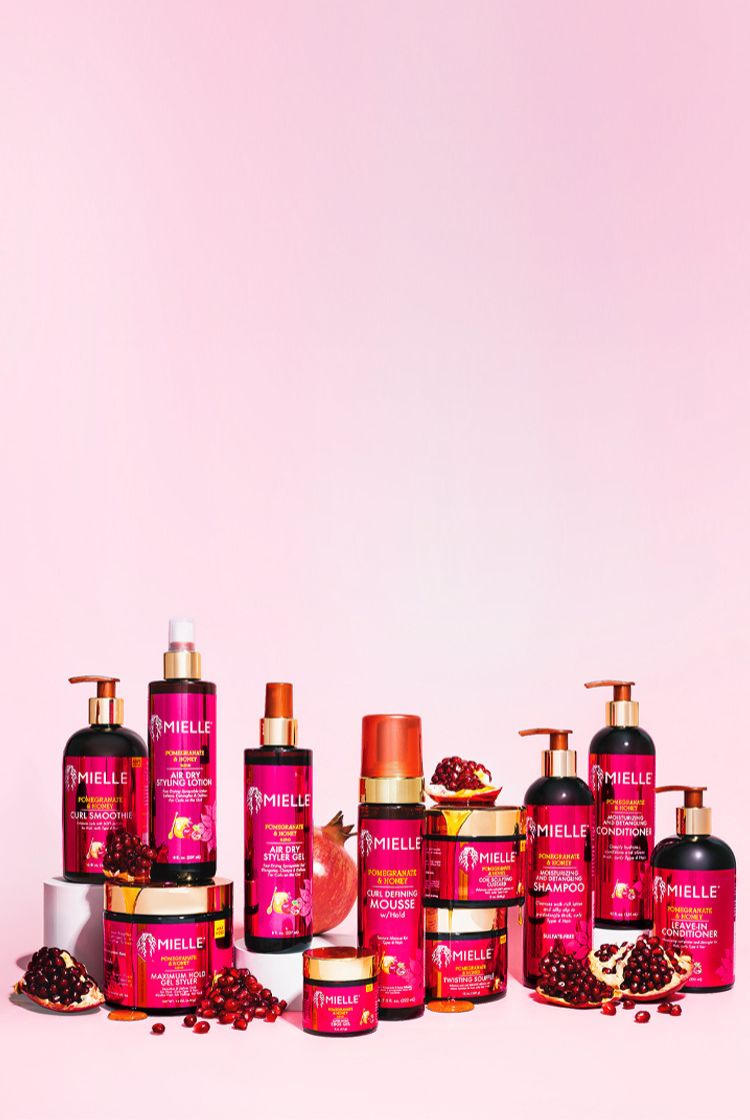 Collection of pink skincare and hair care products on a pink background